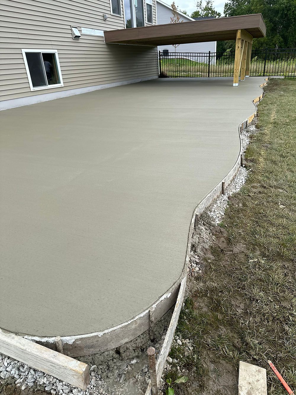 A concrete patio is being built in front of a house.