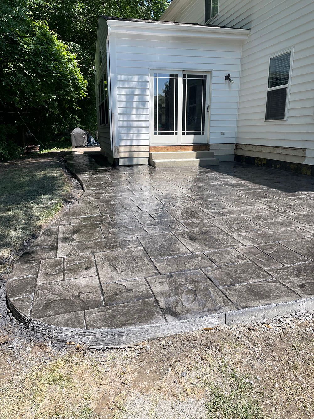 A patio is being built in front of a white house.