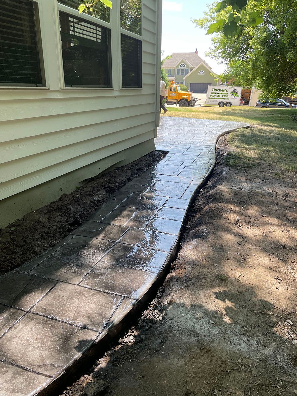 A sidewalk is being built in front of a house.
