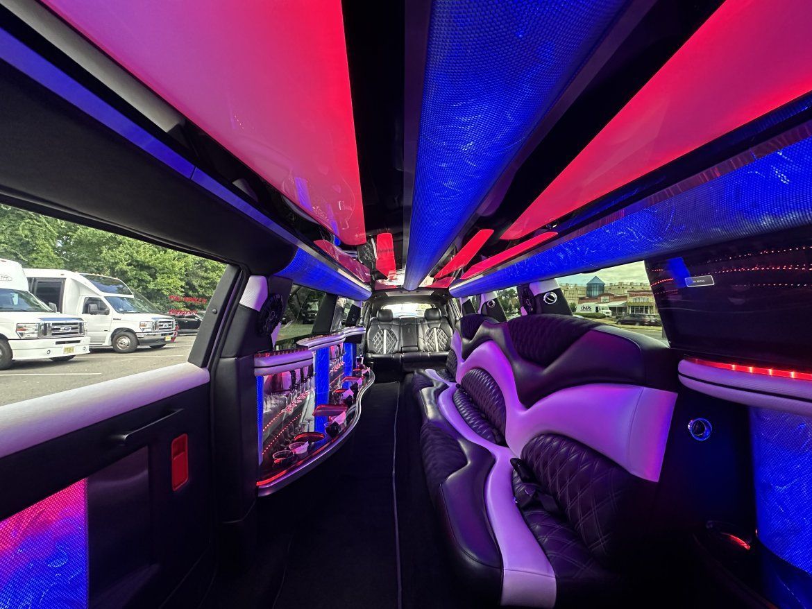 Interior of a limousine with red and blue LED lighting and black seats.