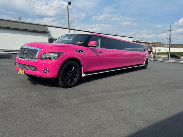 Pink limousine parked on asphalt.