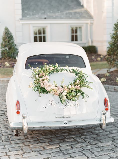White vintage car with floral wreath and
