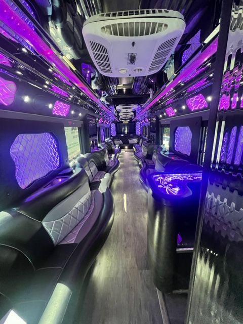 Inside a black limousine with purple neon lighting, seating.