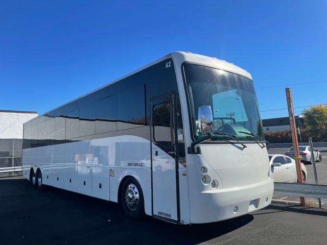 White passenger bus parked outside on a sunny day.