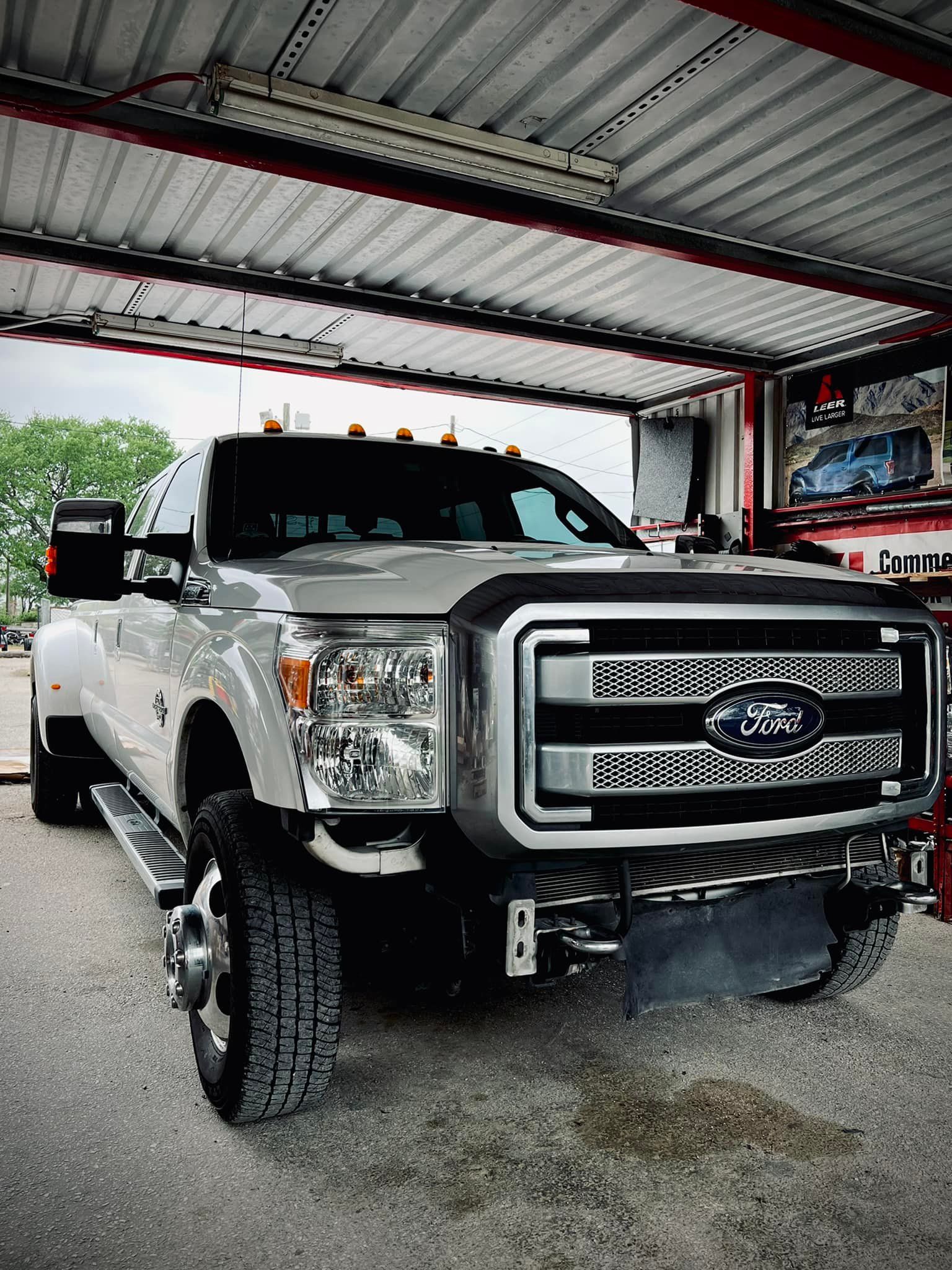 Silver Ford pickup truck parked under a metal awning.