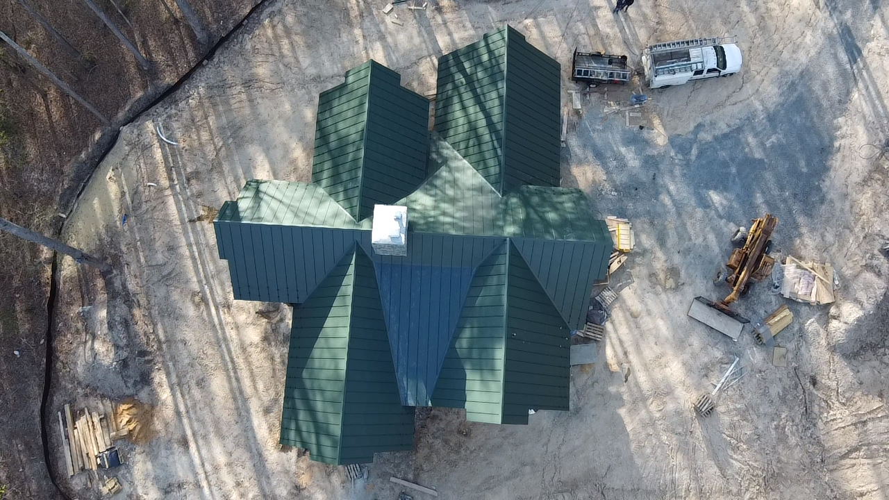 An aerial view of a house under construction with a green roof.