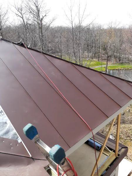 A ladder is sitting on top of a brown roof