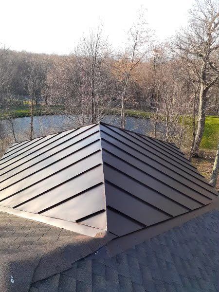 A roof with a pyramid shaped roof and a river in the background