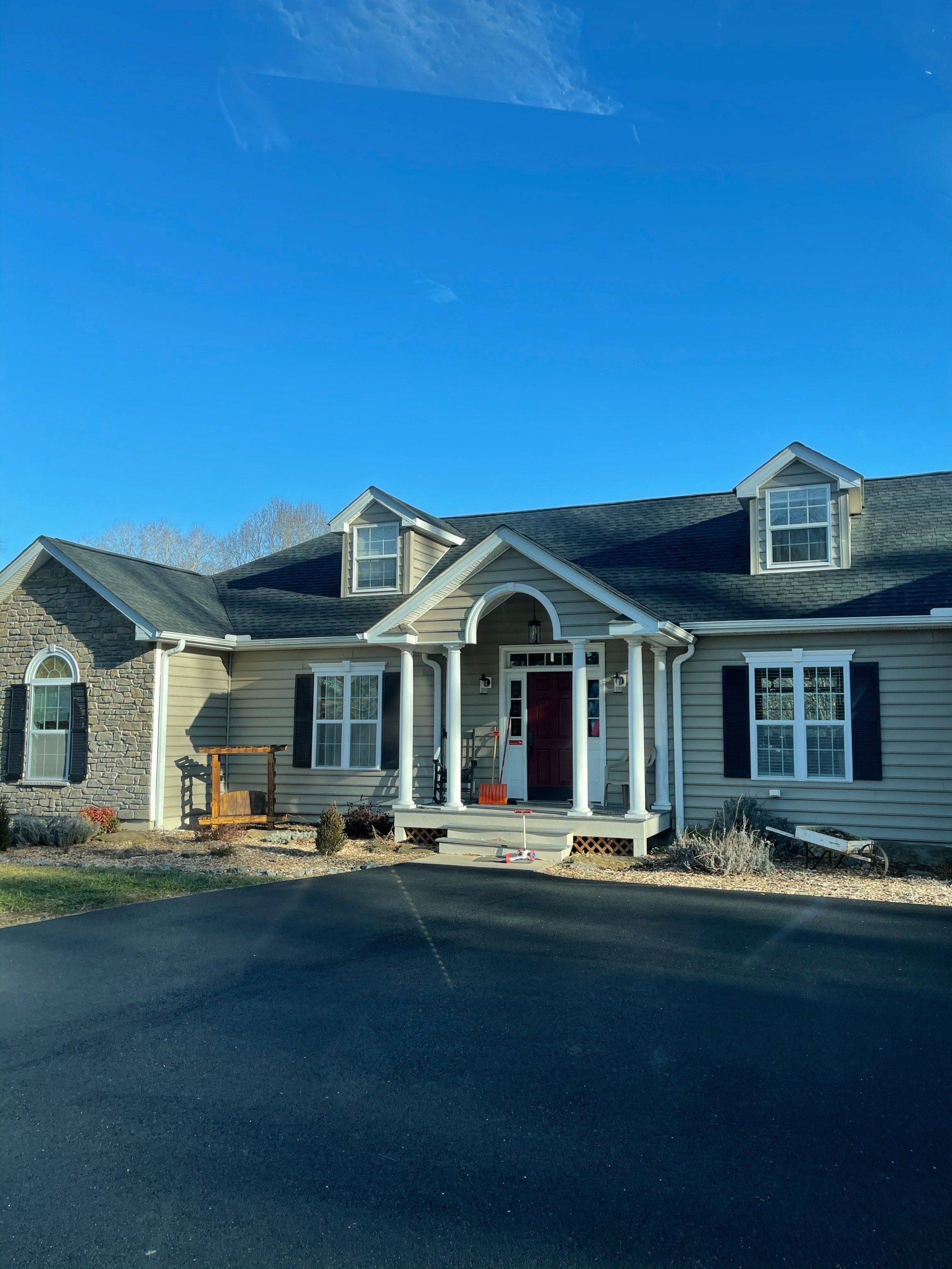 A large house with a porch and a blue sky in the background