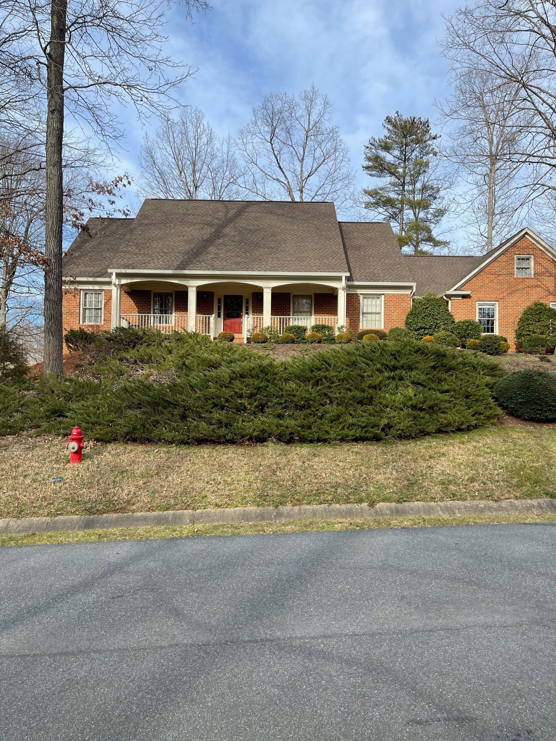 A large brick house with a red fire hydrant in front of it.