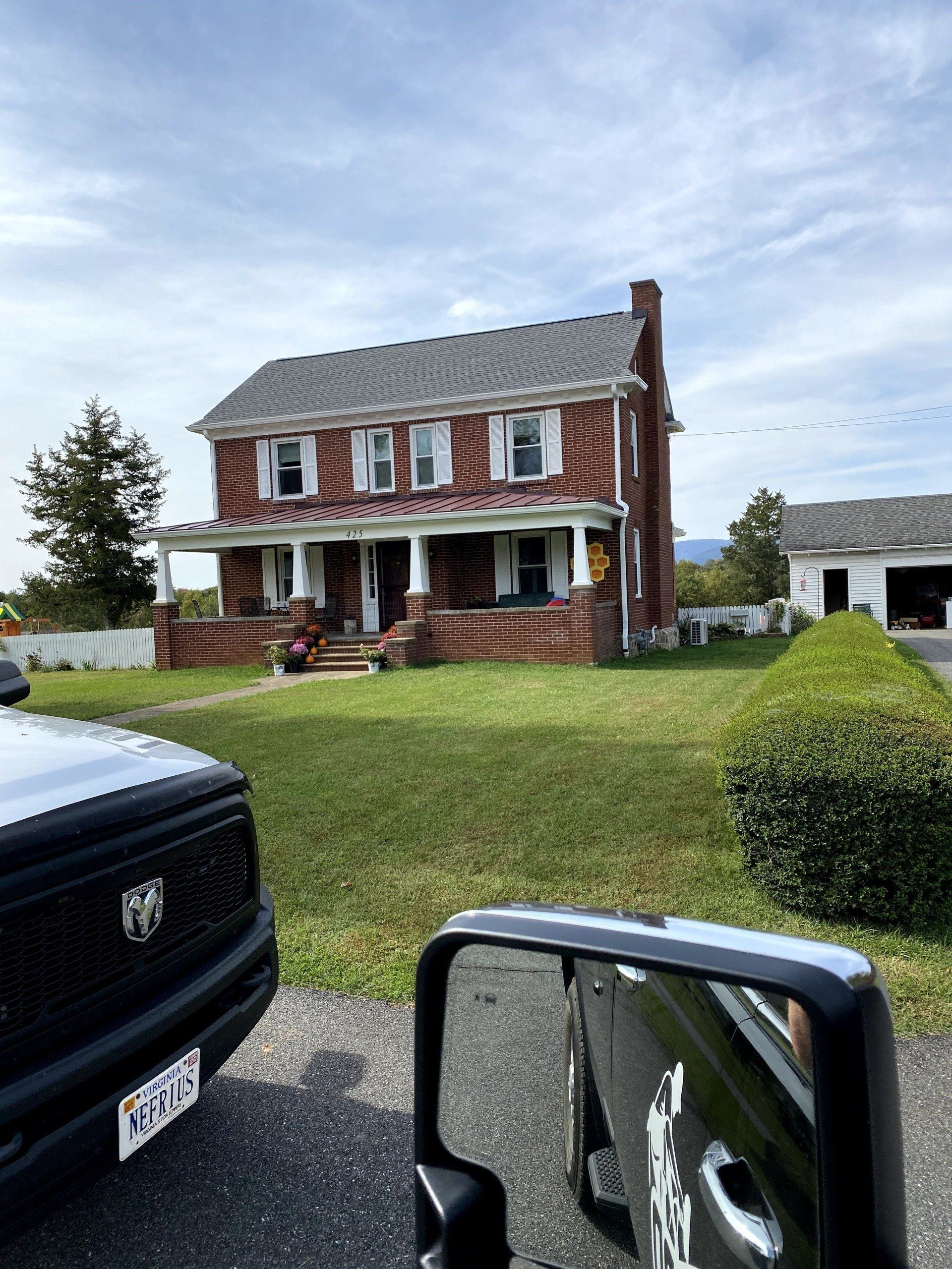 A truck is parked in front of a large brick house.
