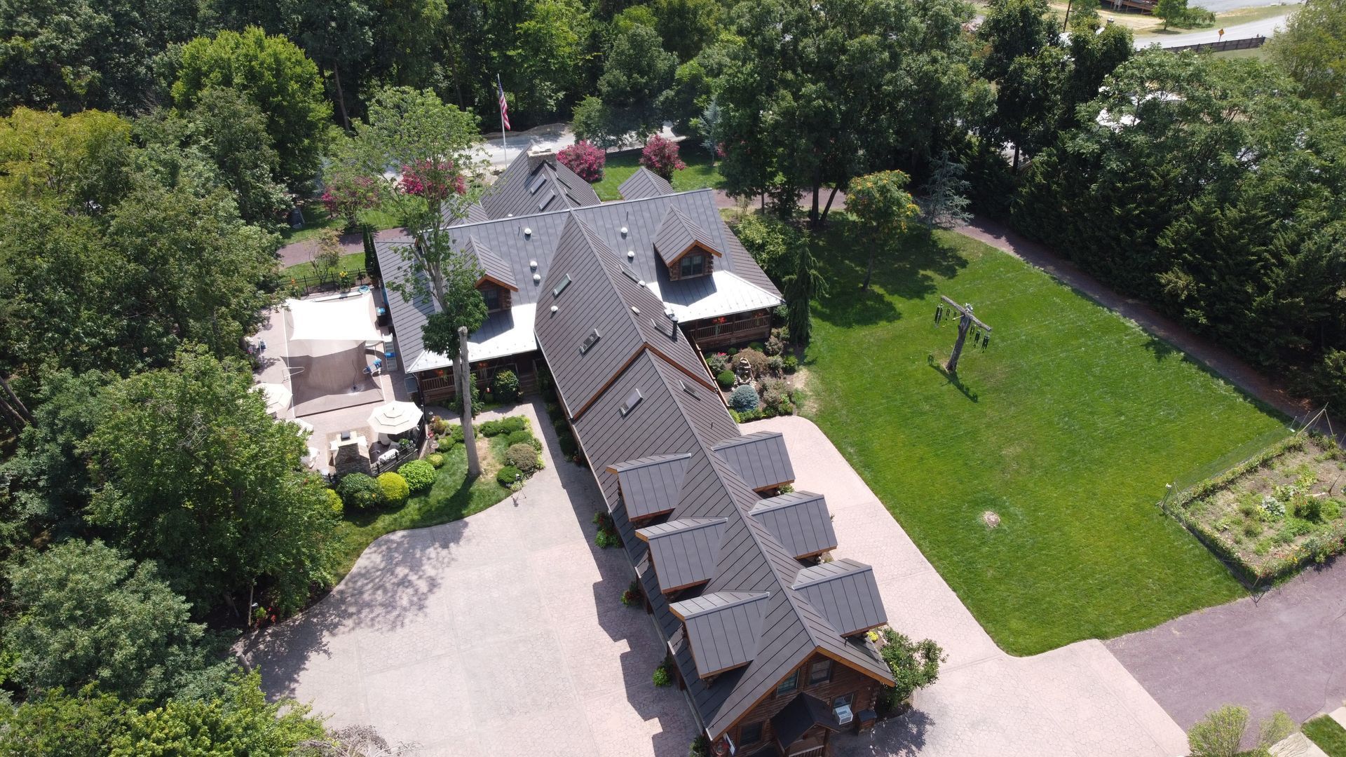 An aerial view of a large house surrounded by trees and grass.