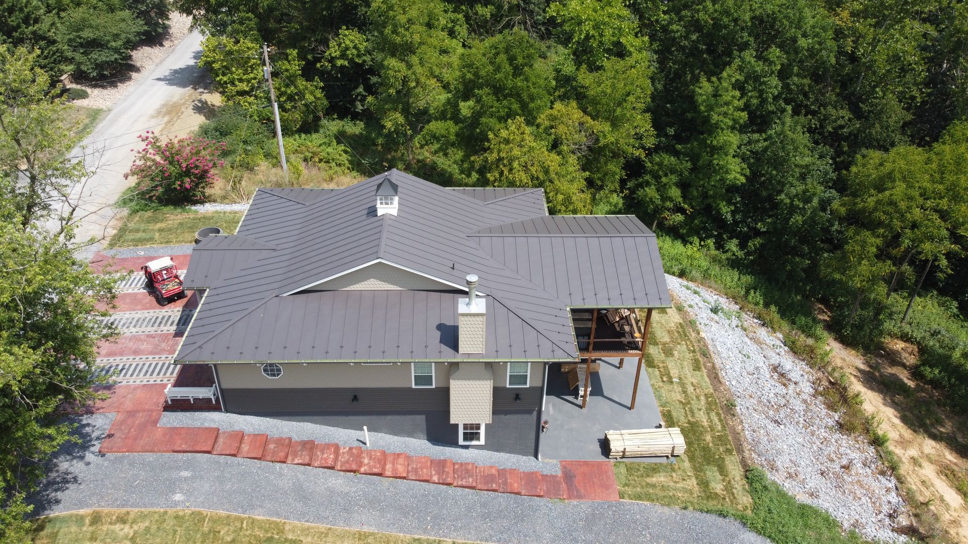 An aerial view of a house on a hill surrounded by trees.