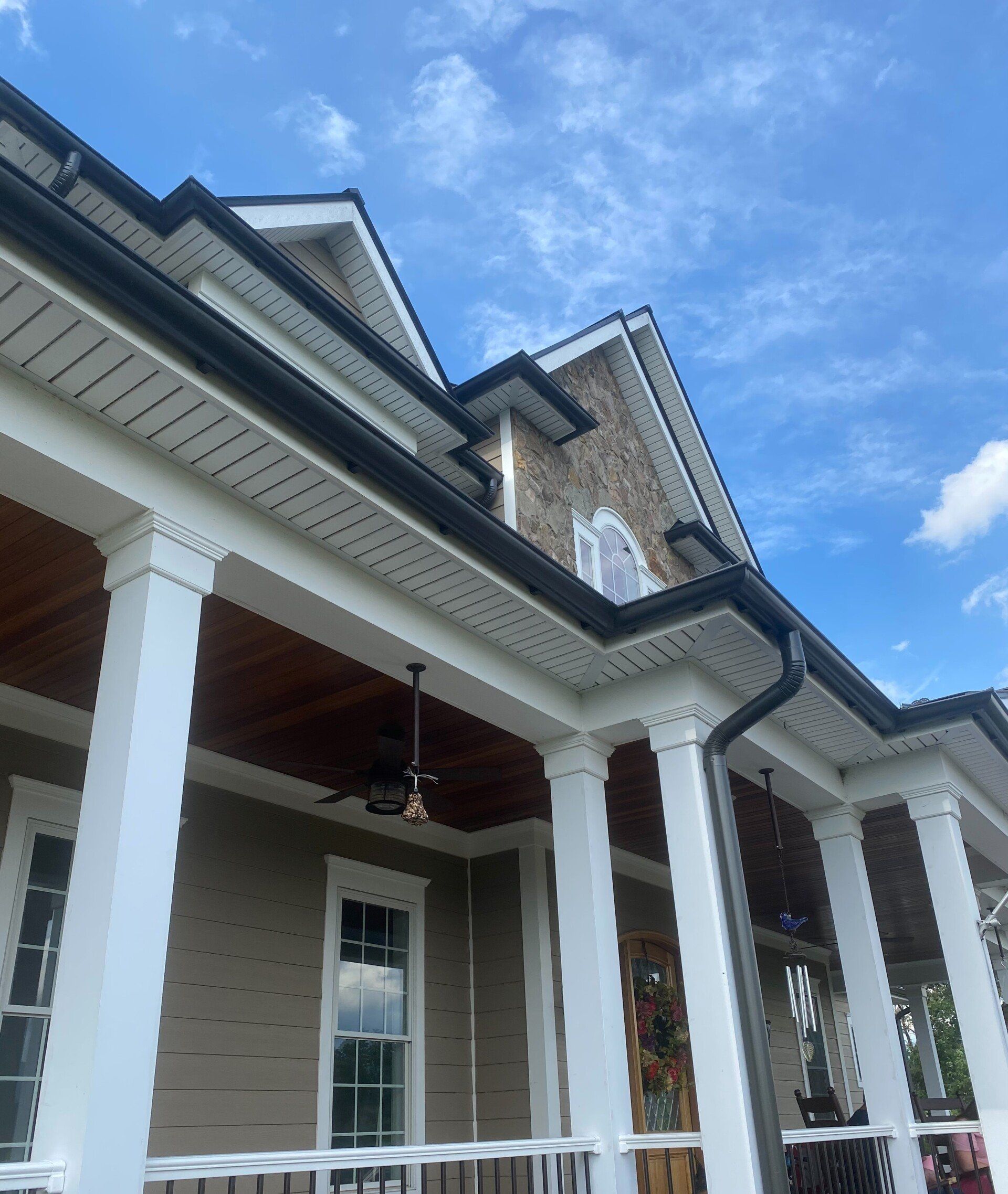A large house with a porch and a ceiling fan