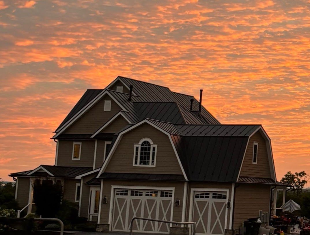 A large house with a sunset in the background