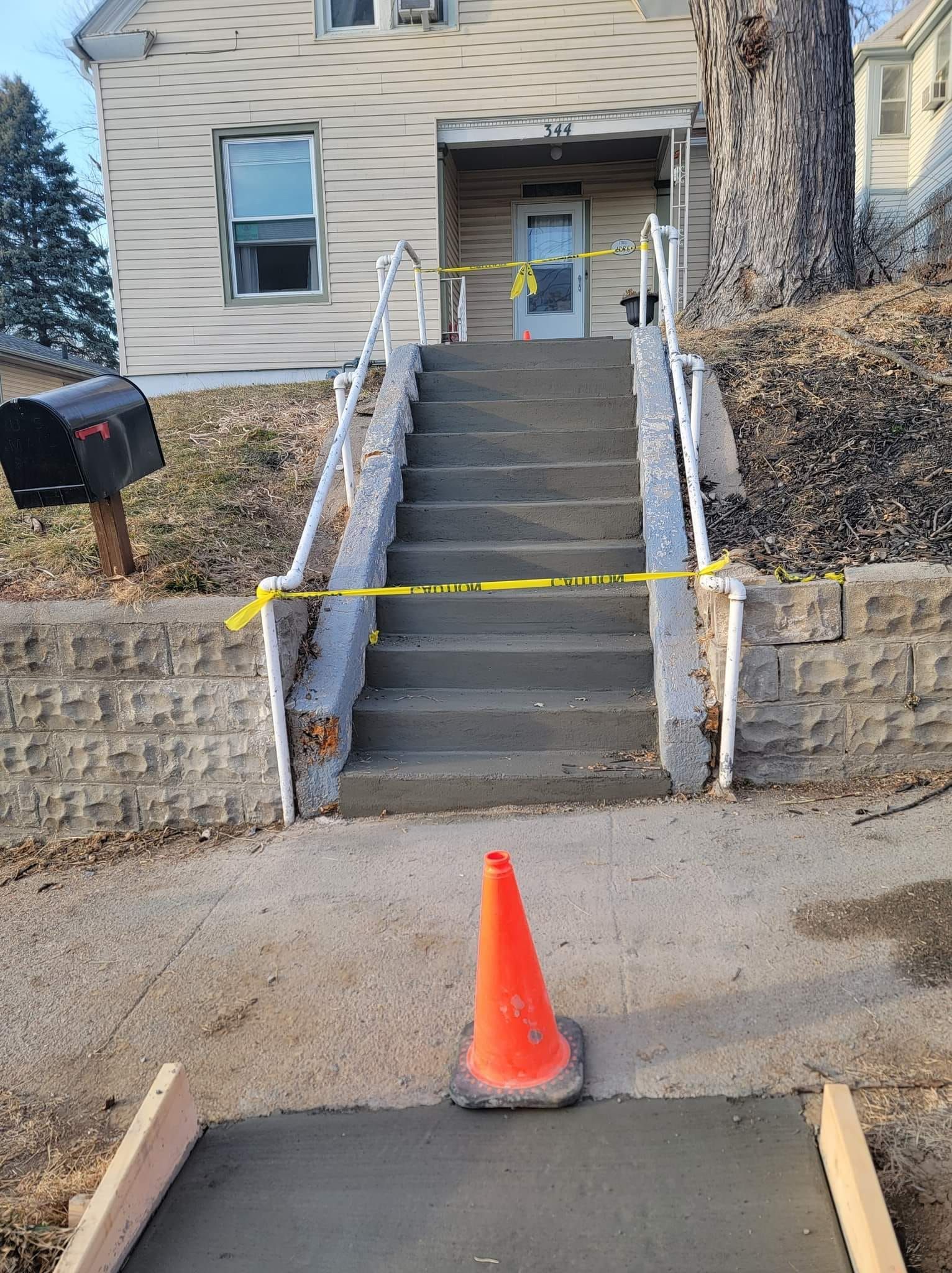 A concrete walkway is being built in front of a house