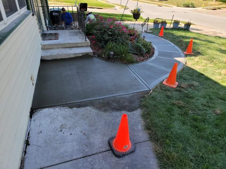 A concrete walkway is being built in front of a house