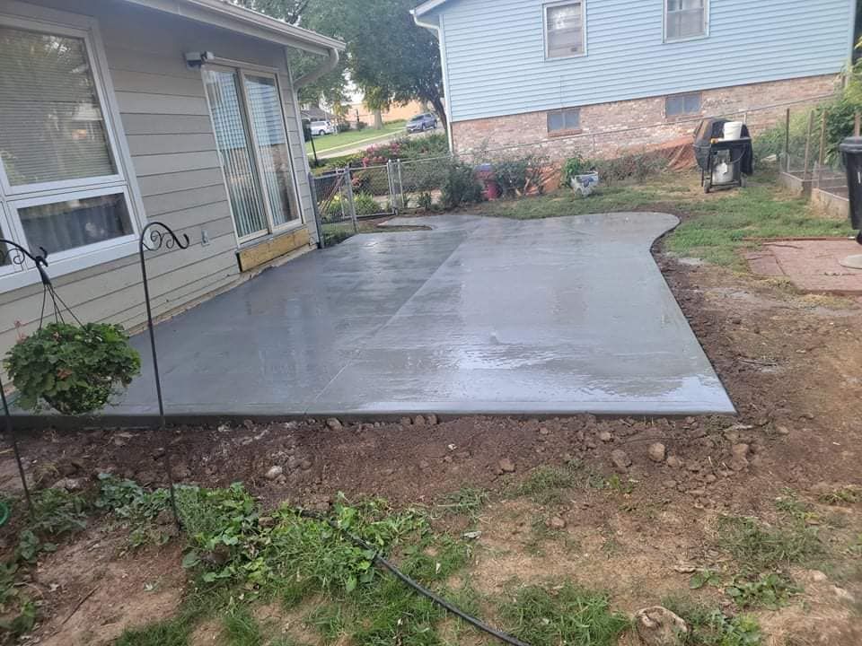 A concrete patio is being built in front of a house