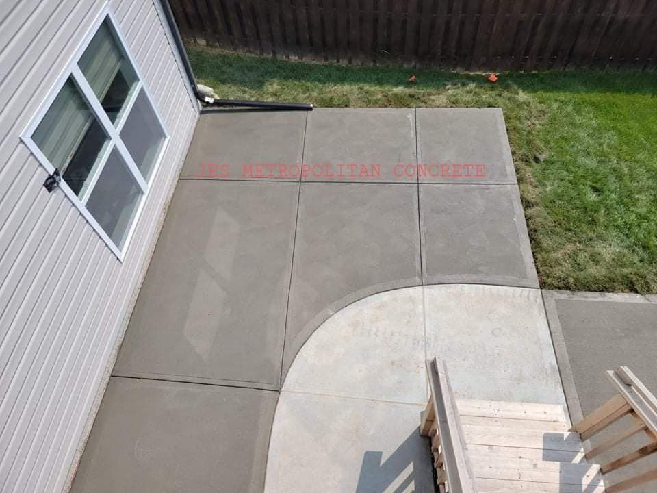 An aerial view of a concrete patio next to a house