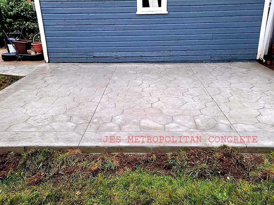 A concrete patio in front of a blue house