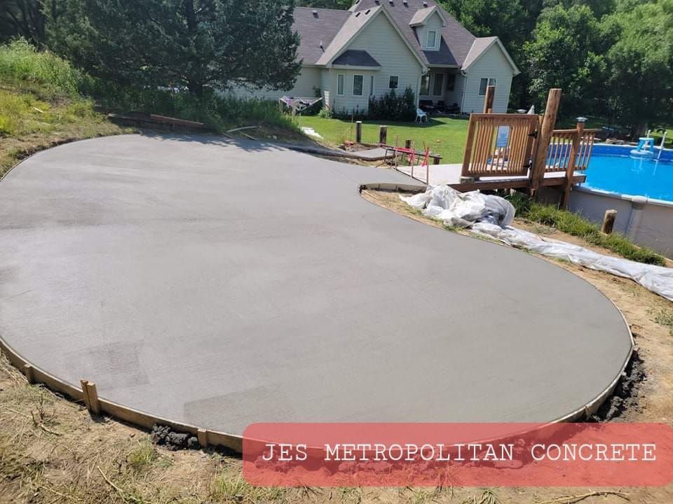 A concrete driveway is being built in front of a house