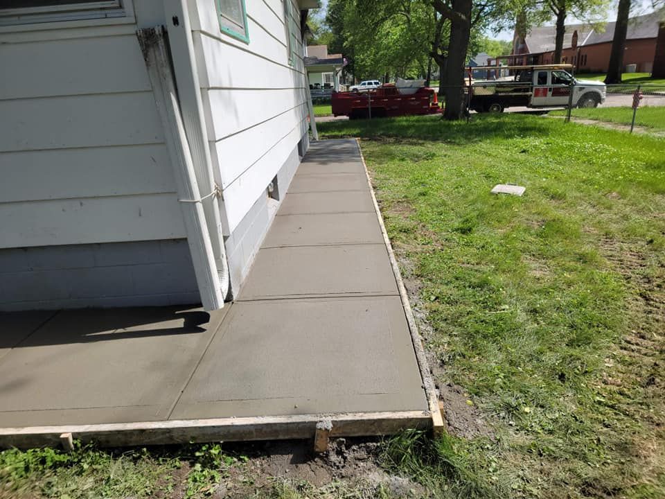 A sidewalk is being built in front of a house
