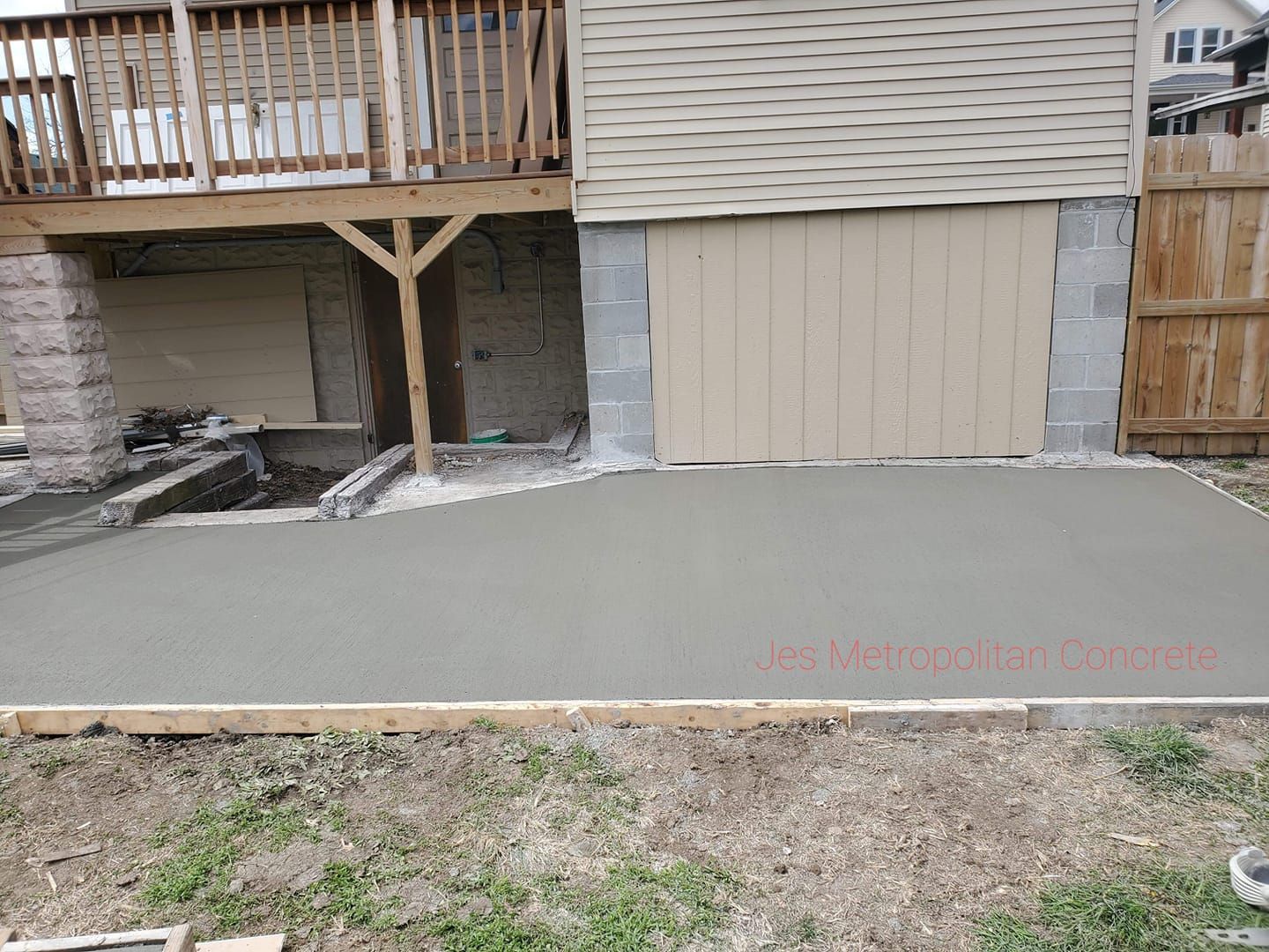 A concrete driveway is being built in front of a house