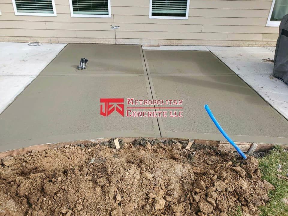 A concrete driveway is being built in front of a house
