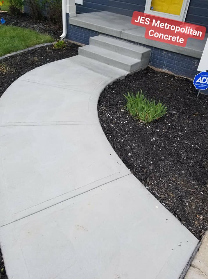 A concrete walkway with steps leading to a house