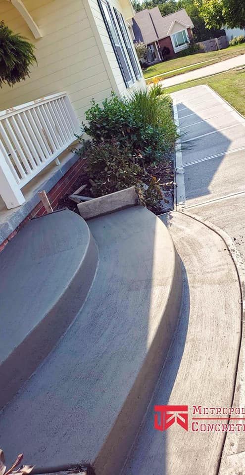 A concrete walkway with steps leading up to a house