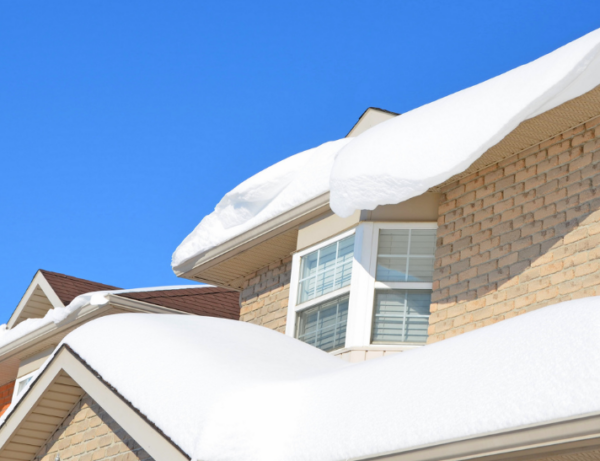A house with a lot of snow on the roof.