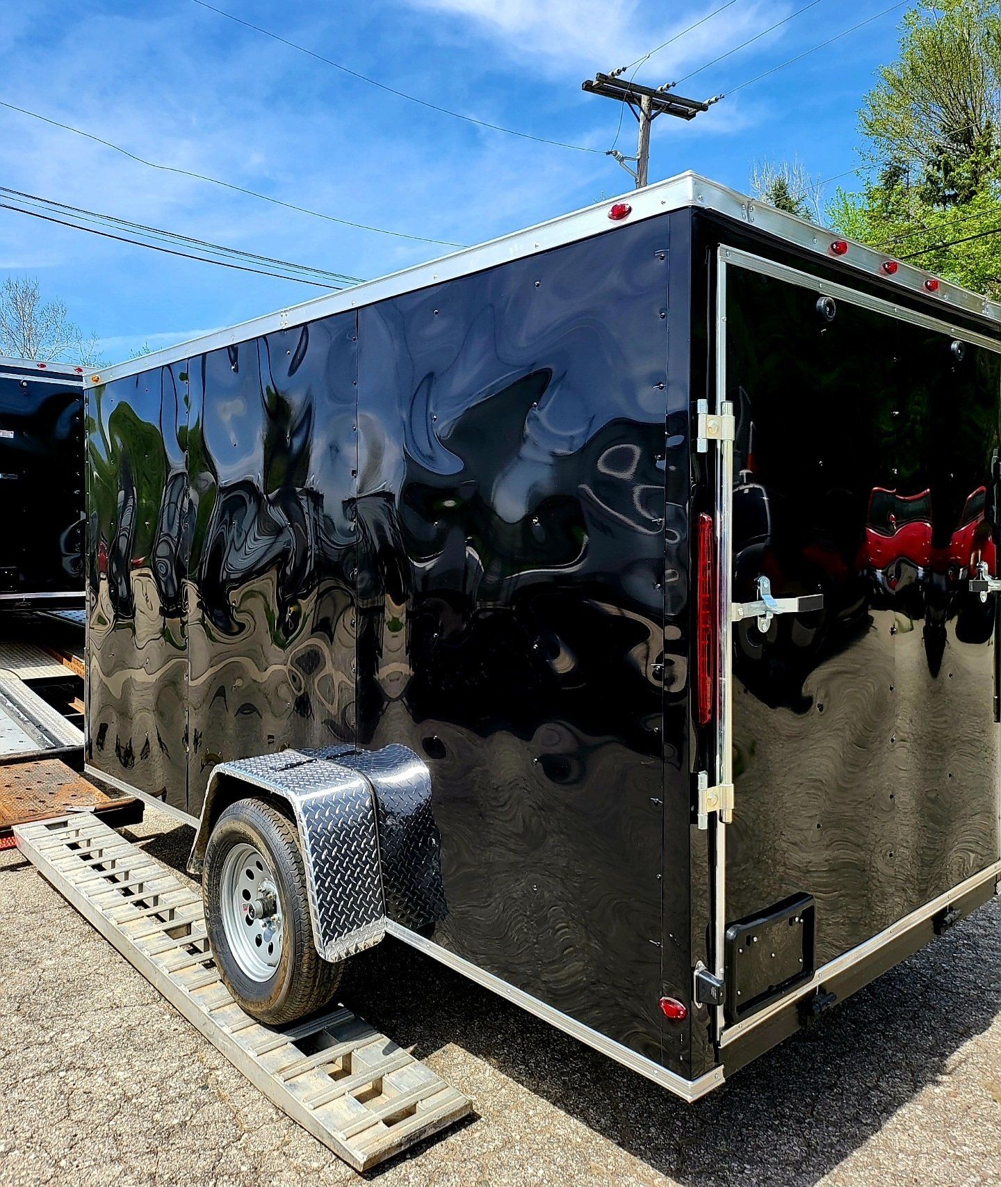 A black trailer is parked on the side of the road.