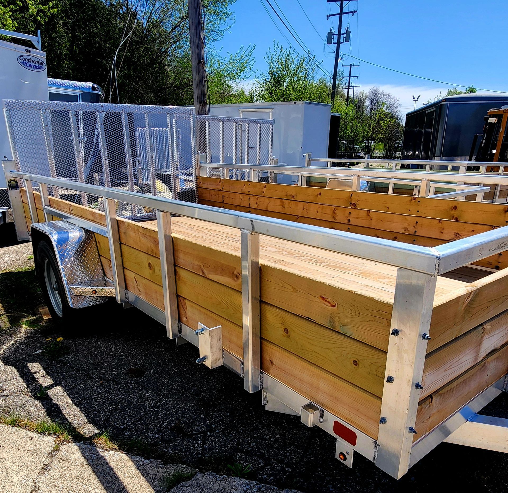 A wooden trailer is parked on the side of the road