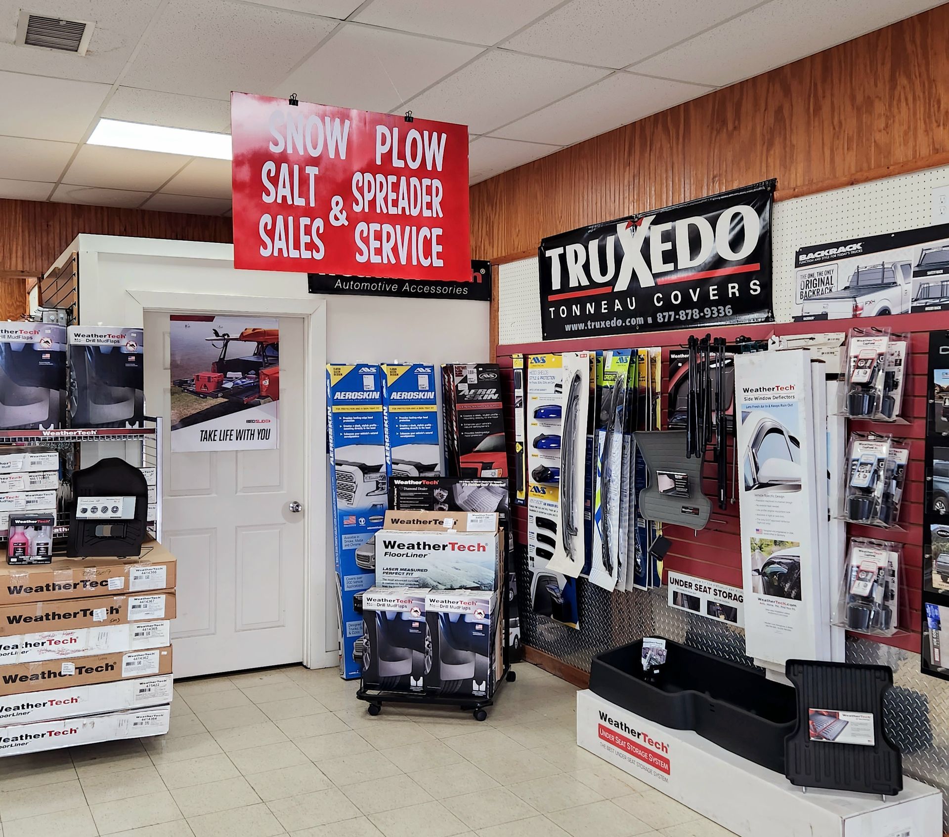 A store with a sign that says snow plow salt & spreader sales service