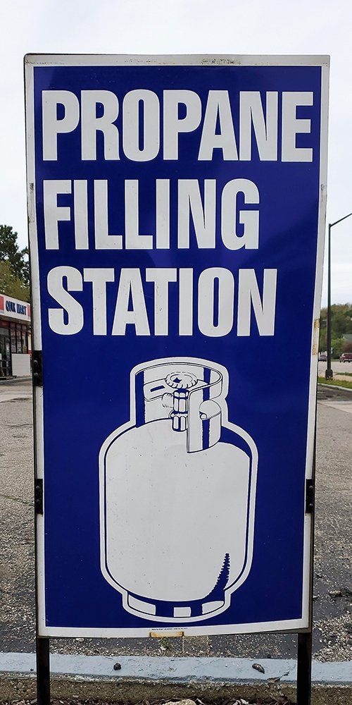 A blue and white sign that says propane filling station