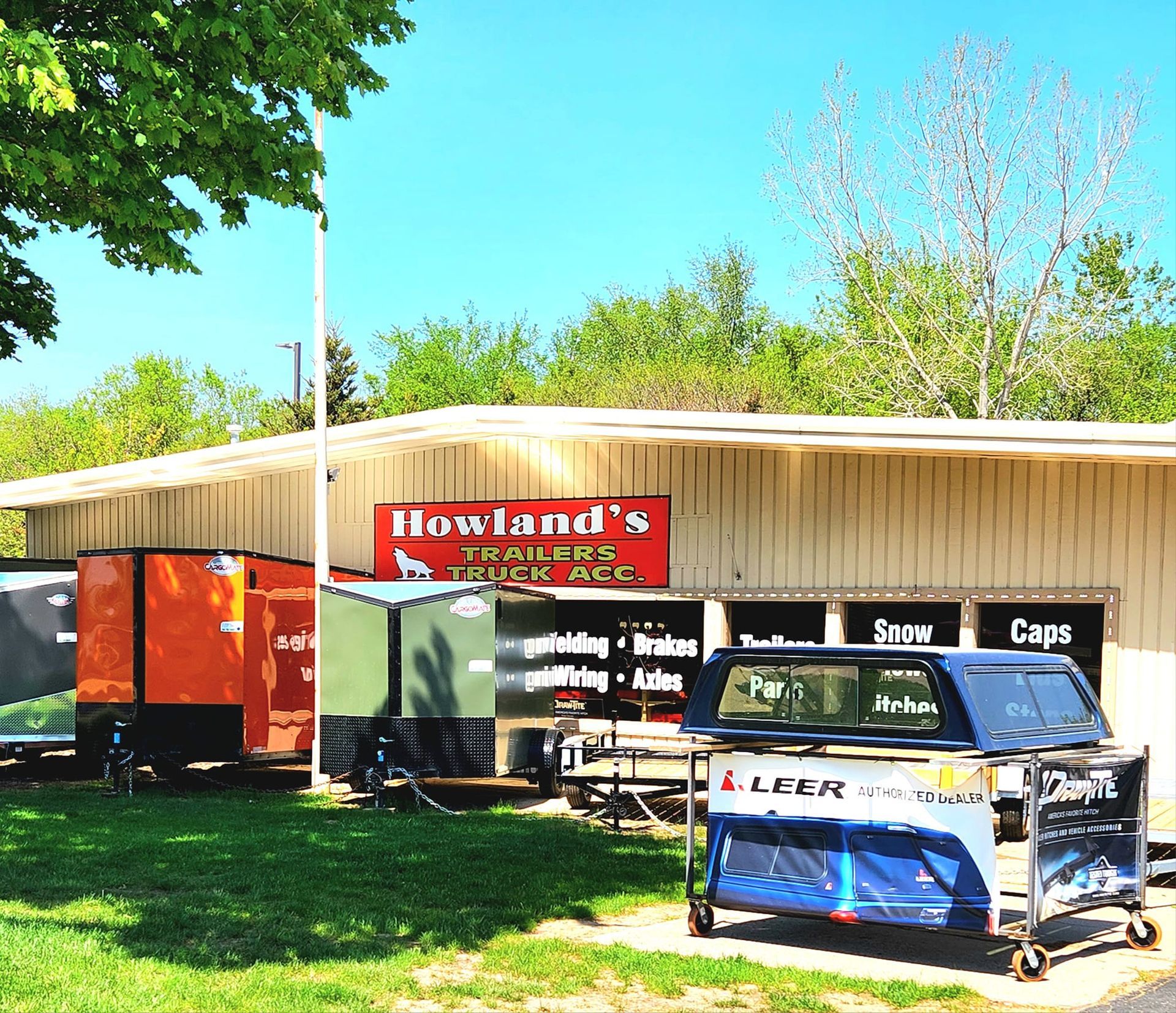 a truck is parked in front of a trailer dealership called Howland's Trailer and Trucks Accessories