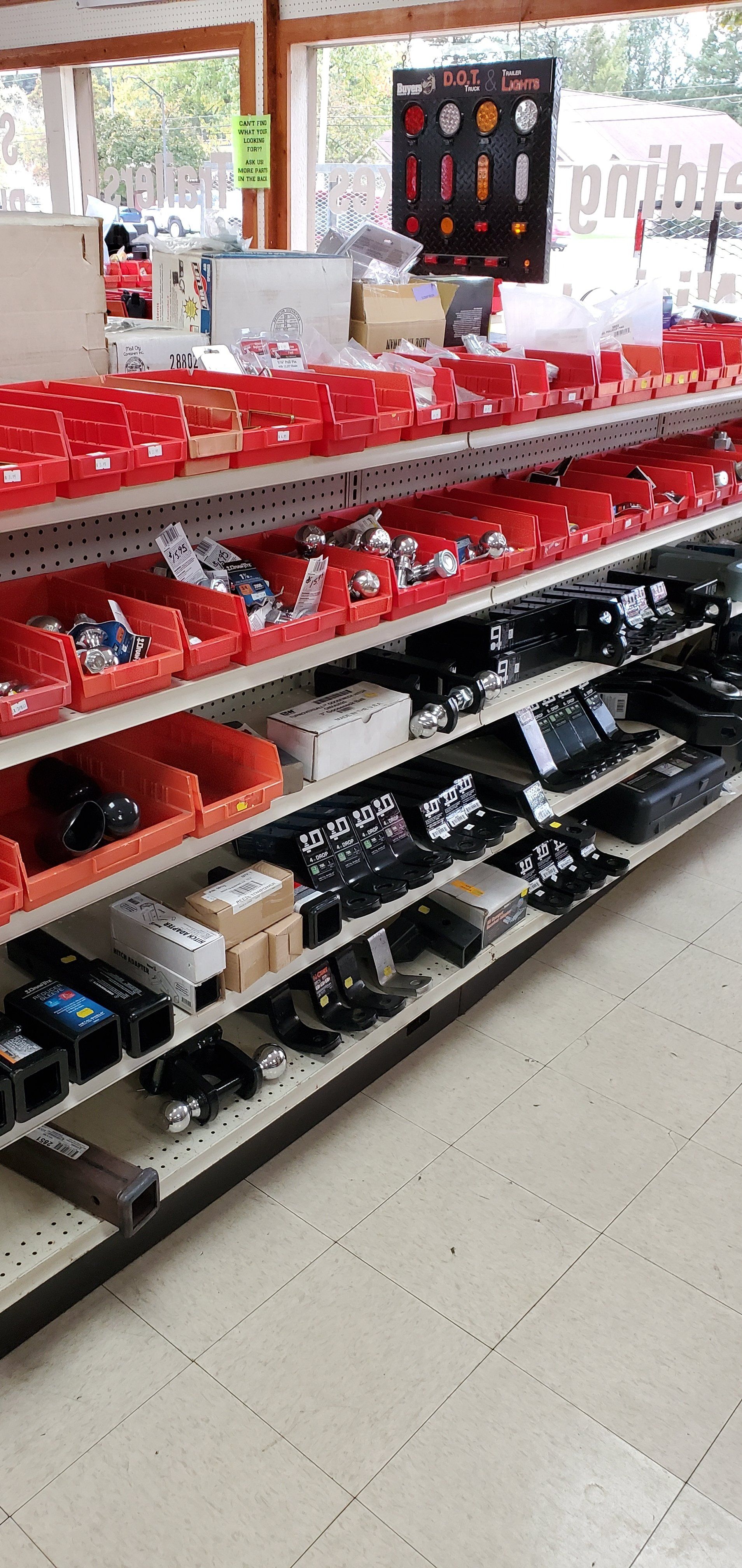 A store shelf filled with lots of red bins and boxes.