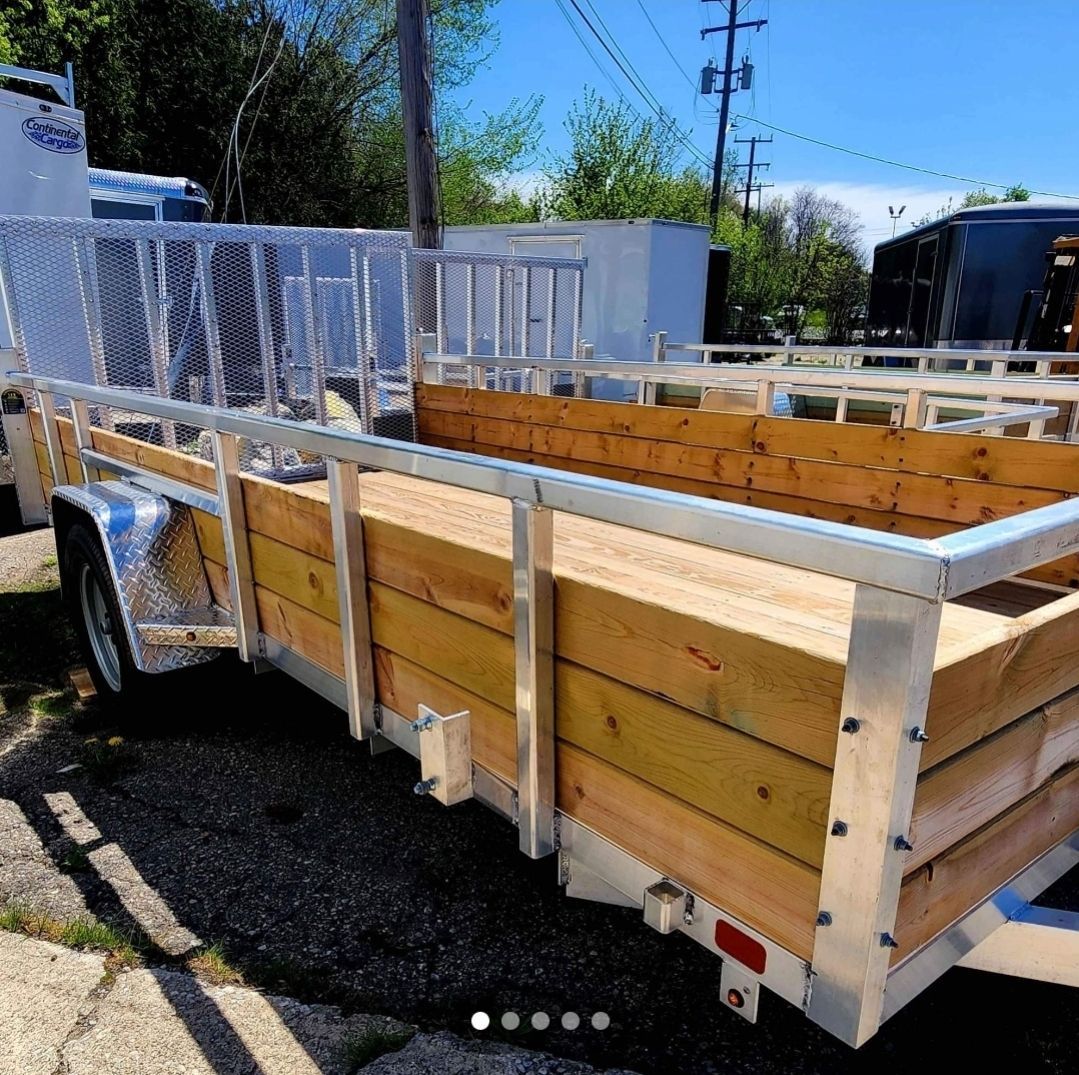 A wooden trailer is parked on the side of the road