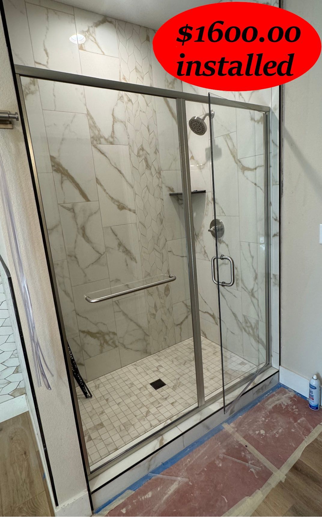 Glass shower enclosure with marble tile