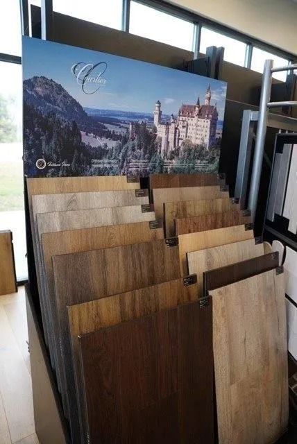 Display of wood flooring samples with a scenic backdrop of a castle and mountains.