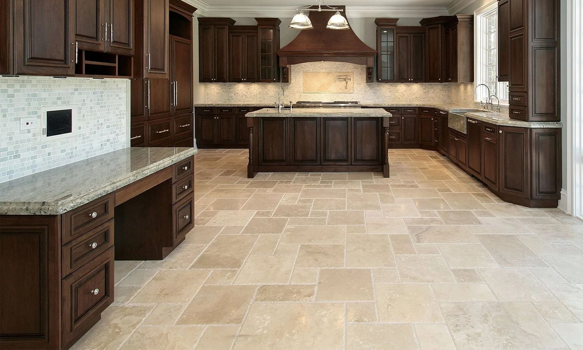 Spacious kitchen with dark wood cabinets, center island, light stone floor, and granite countertops.