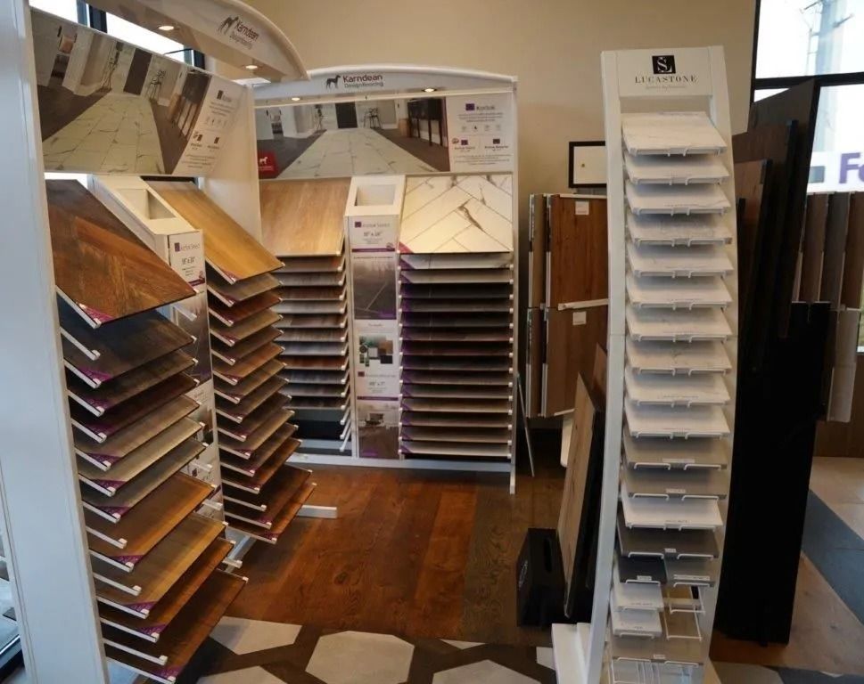 Displays of various flooring samples in a showroom, including wood, tile, and stone patterns.