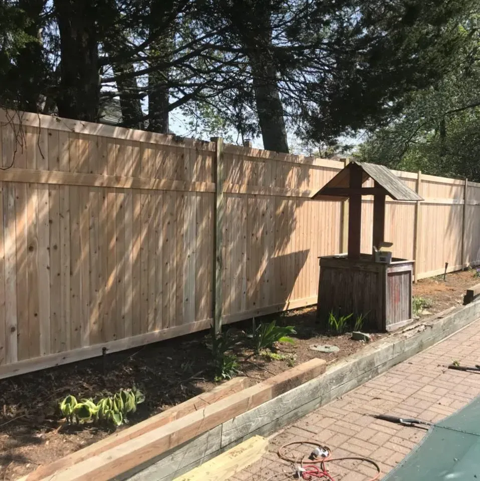 A wooden fence with a well in the middle of it