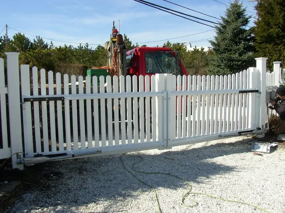 A white picket fence with a red truck in the background
