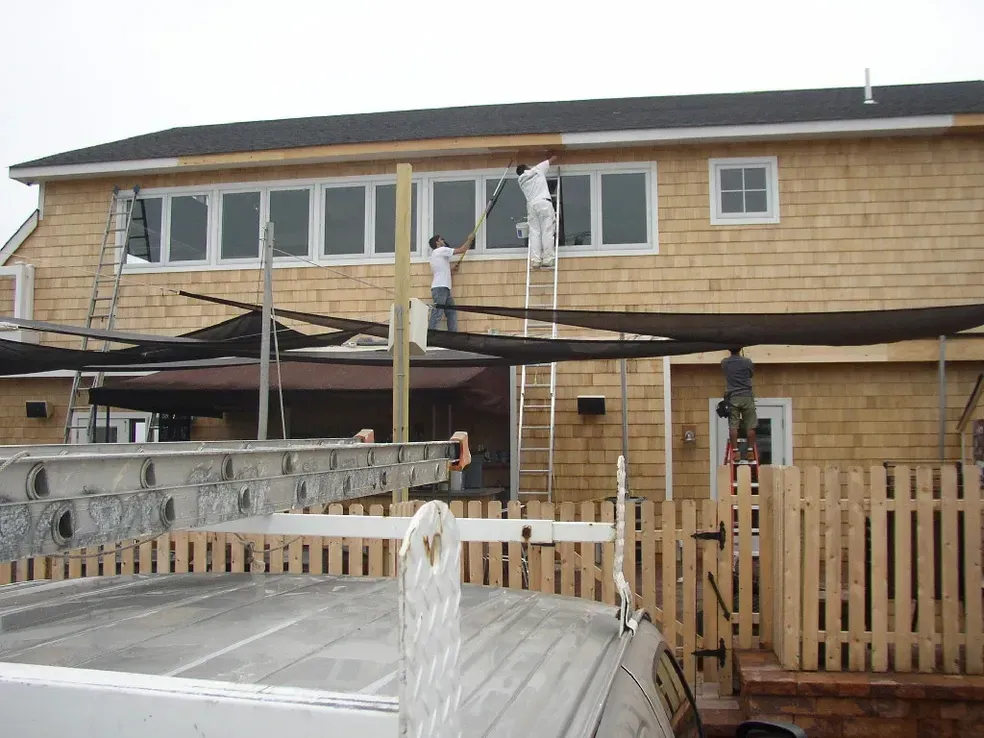 A house is being painted by a group of people