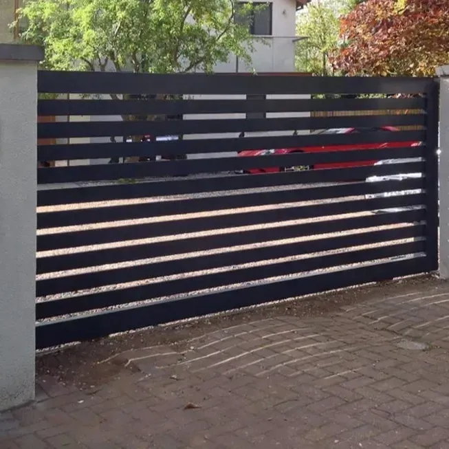 A black fence with a red car parked behind it