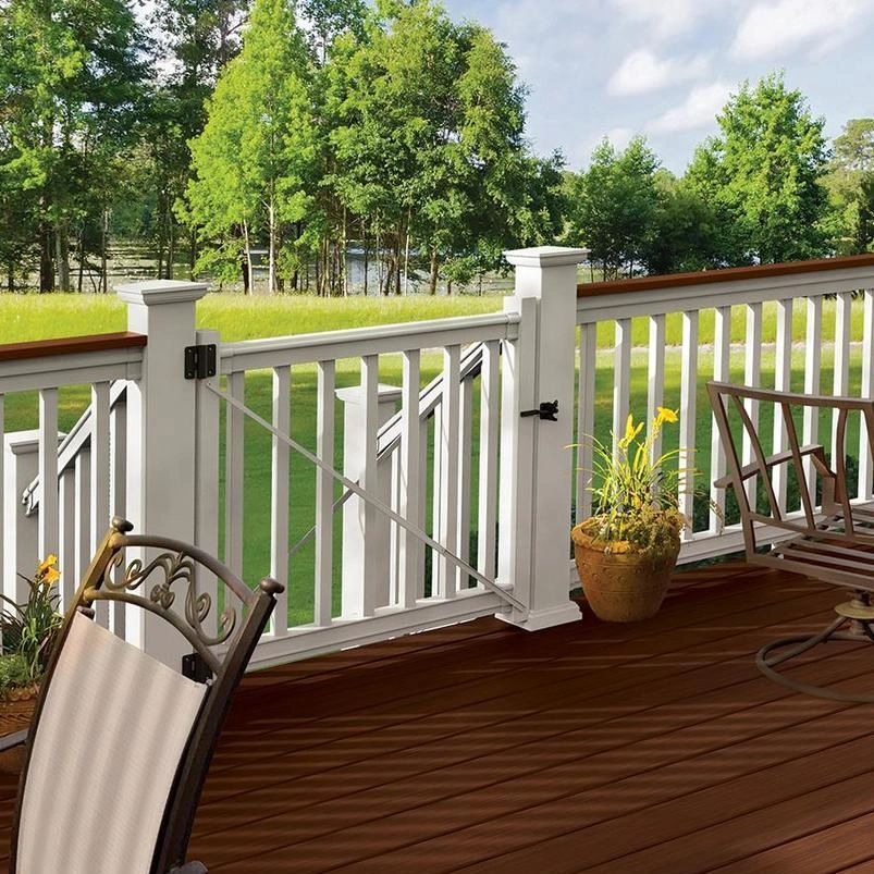 A wooden deck with a white railing and a chair