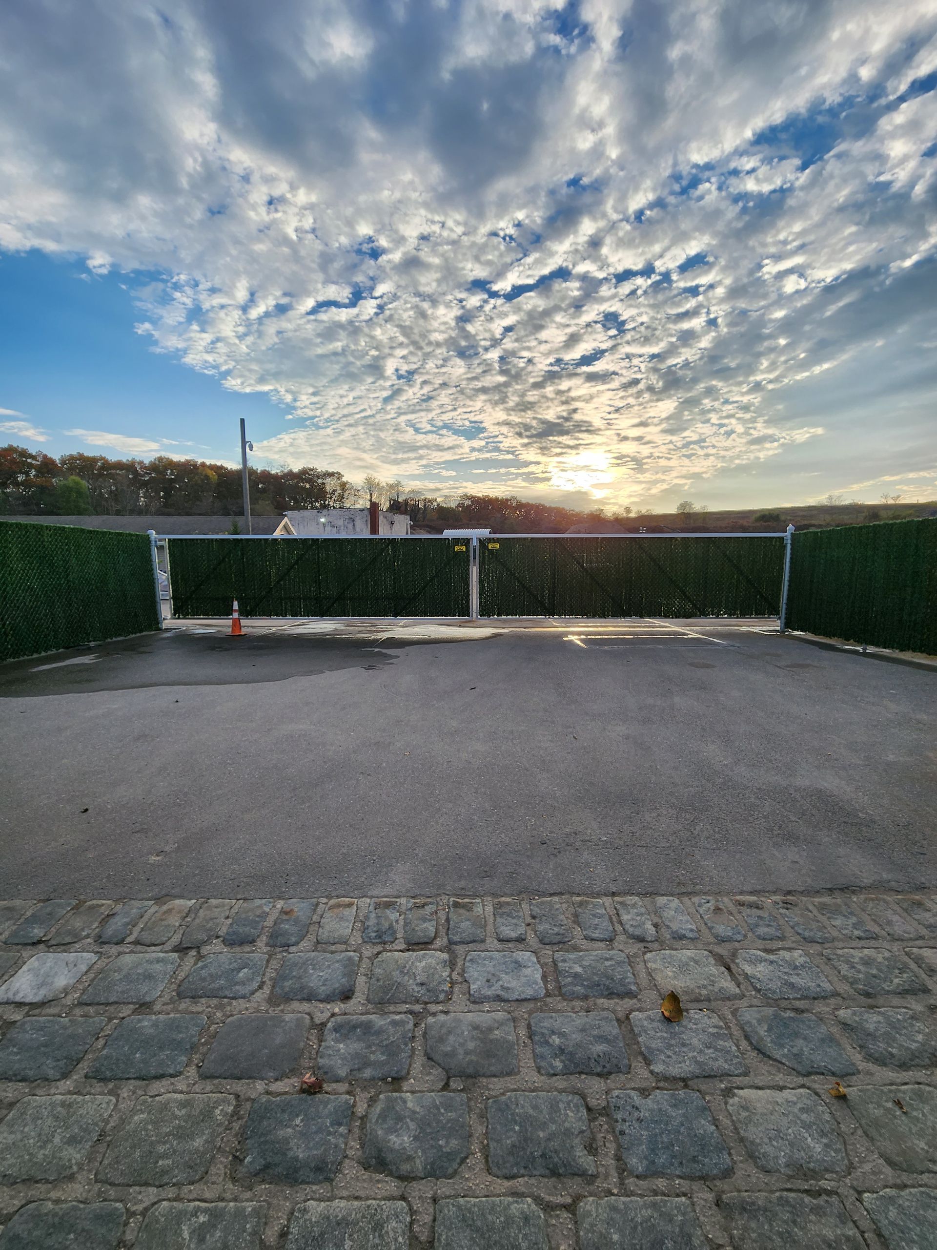 A white fence is in front of a house with a pergola.