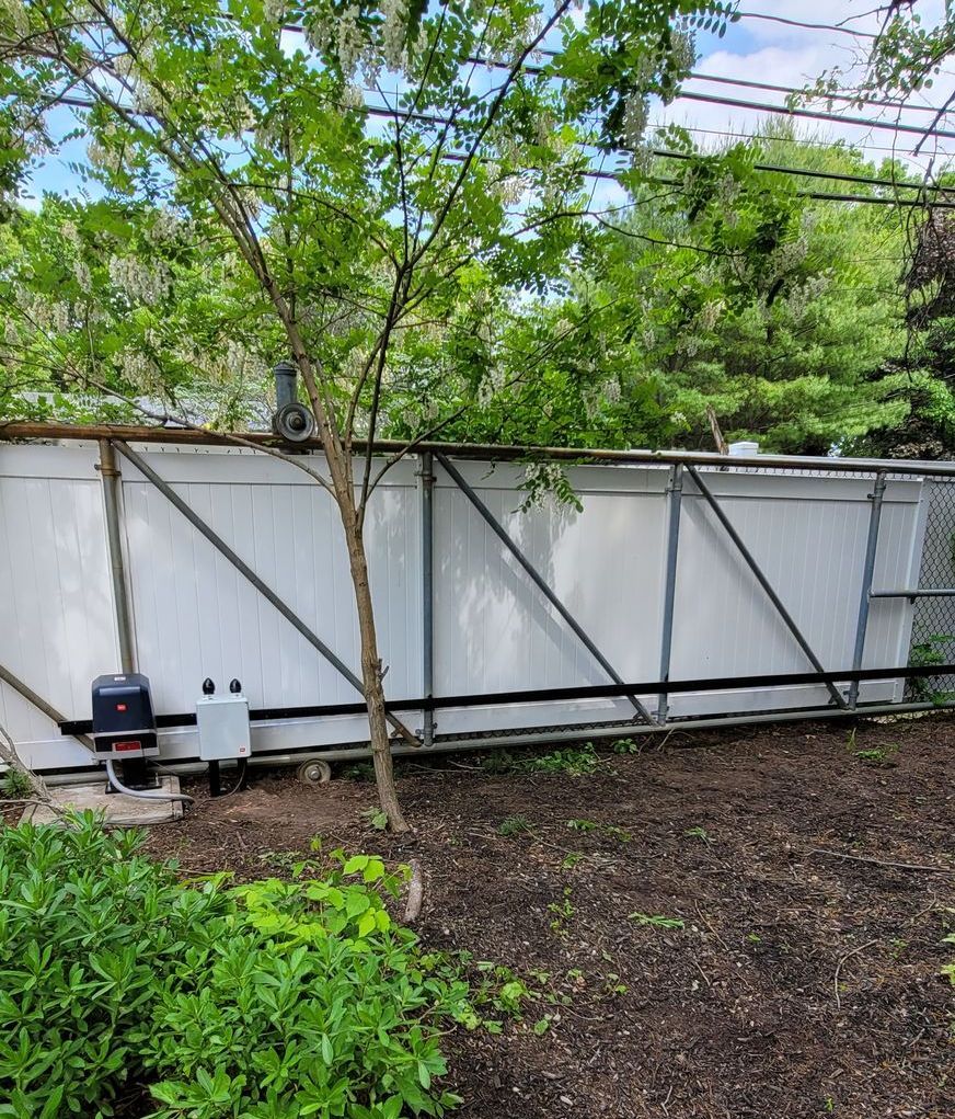 A wooden gate is open to a grassy area