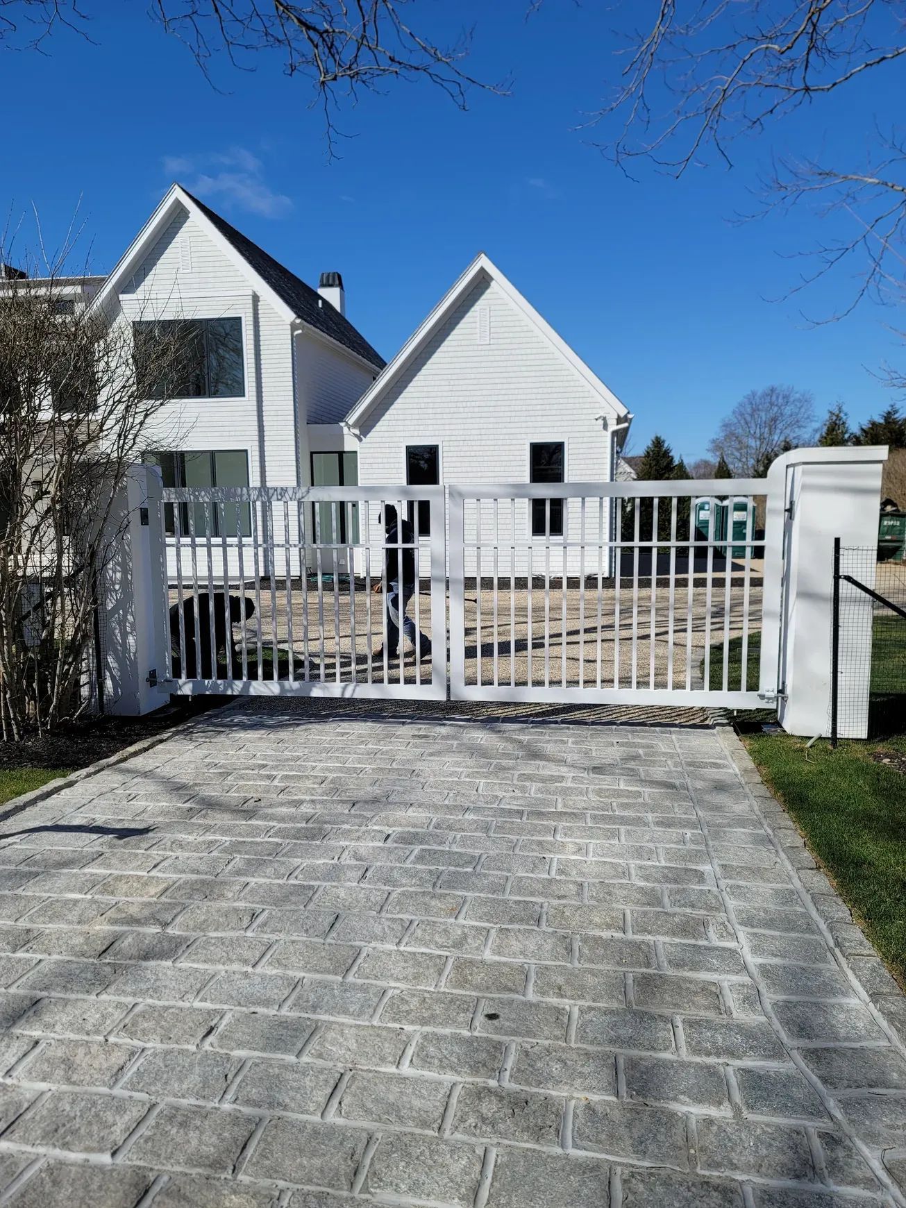 A white house with a sliding gate in front of it.